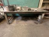 une table sur laquelle se trouve un seau, au milieu d'une pièce
