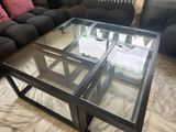 a glass coffee table with a glass top on a marble floor
