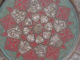 une assiette décorative posée sur une table recouverte d'une nappe rouge