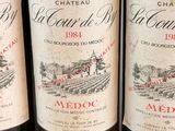 three bottles of red wine sitting on a table next to each other