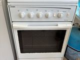 un four de cuisine blanc posé à côté d'une machine à laver