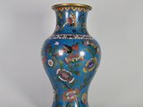 un vase bleu posé sur une surface blanche, avec un fond blanc