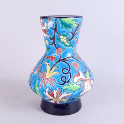 un vase bleu orné d'un motif floral