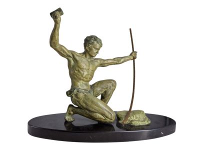 statue en bronze représentant un homme agenouillé sur un rocher, tenant une lance