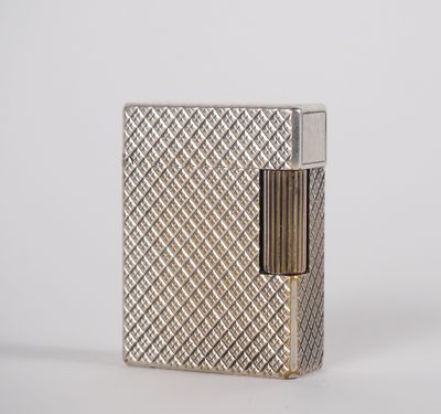 a silver lighter sitting on top of a table next to a white wall