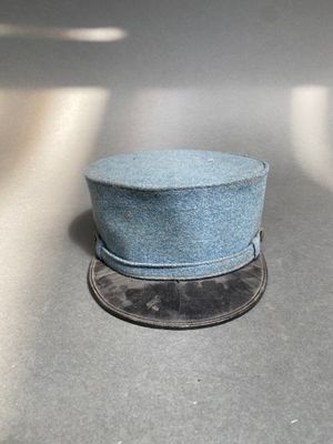un chapeau bleu posé sur une pièce de monnaie posée sur une table