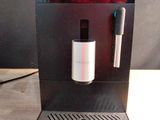 Quelqu'un prend une photo d'une machine à café posée sur une table.