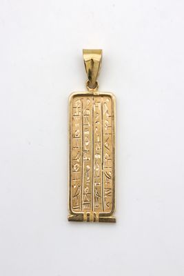 un pendentif plaqué or orné d'un hiéroglyphe égyptien