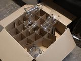 a cardboard box with a bunch of empty wine glasses in it