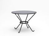 une table noire avec un piètement en métal et un plateau en verre