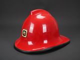 un gros plan d'un casque de pompier rouge sur fond noir