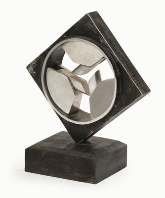 une sculpture en métal posée sur un socle en bois