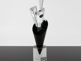 a glass vase with three knives in it on a table