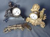 trois horloges et une figurine posées sur une table