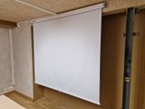 un écran de projection dans un coin de la pièce