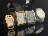several watches are lined up in a row on a black surface