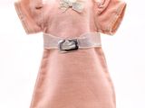 robe rose posée sur un présentoir à mannequin, ornée d'un nœud blanc