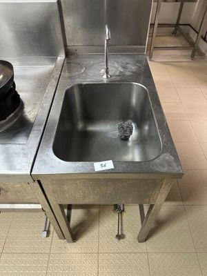 un évier au milieu d'une cuisine, avec une casserole posée sur le plan de travail