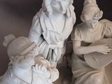 a statue of a man playing a guitar next to a statue of a woman