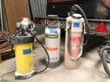 two fire extinguisors sitting next to each other in a garage
