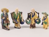 three chinese figurines of men with hats and carrying bags