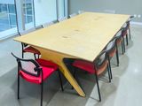 a long table with red chairs and a yellow table top