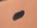 the back of a tan briefcase with a black label on it