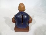 une figurine d'un homme assis sur une chaise