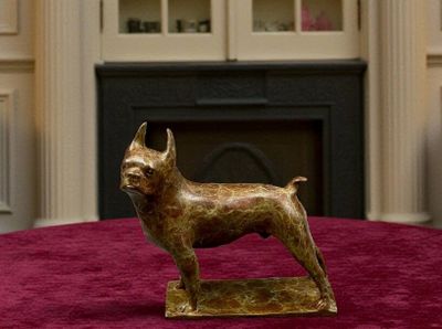 statue d'un chien posée sur une table devant une cheminée