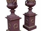 pair of decorative urns on pedestals on a white background