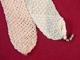 two pieces of crochet on a red surface