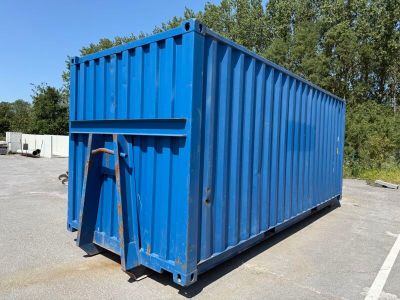 a blue container sitting in a parking lot with trees in the background