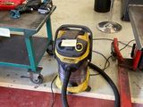 un aspirateur posé par terre à côté d'une table