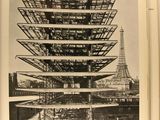 black and white photograph of a building with a tower in the background