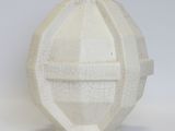 a white vase with a face on it on a white surface