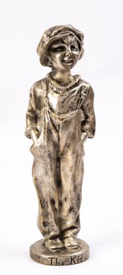 statue d'un garçon en salopette et coiffé d'un chapeau, sur fond blanc