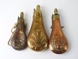 three antique brass bottle shaped ornaments on a white background