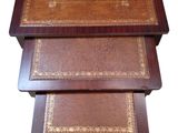 trois tables en bois avec des plateaux en cuir, montées sur roulettes, sur fond blanc