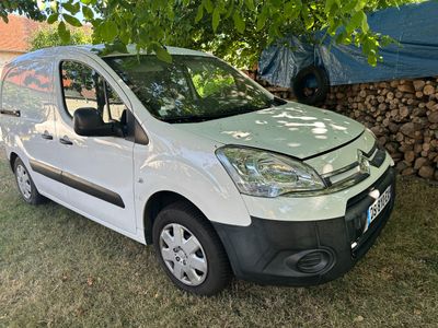 La camionnette blanche est garée à l'ombre d'un arbre.