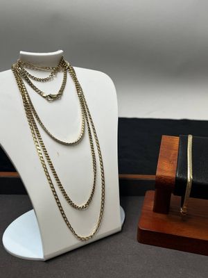 deux colliers et un bracelet posés sur un présentoir posé sur une table