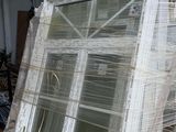a pile of old windows sitting outside of a building