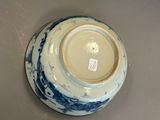 a blue and white bowl on a table with a tag on it