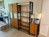 une pièce avec une bibliothèque et une lampe posée au sol