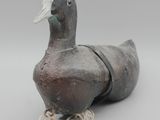 un vieux canard en bois posé sur une corde
