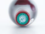 a close up of a bottle of wine on a white surface