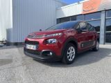 une citrole rouge garée devant un immeuble