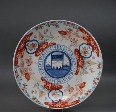JAPON. PLAT en porcelaine émaillée polychrome à décor Imari. Travail X