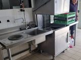 a man that is standing in a kitchen with a sink