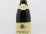 a close up of a bottle of wine on a white surface
