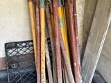 a lot of baseball bats that are leaning up against a wall